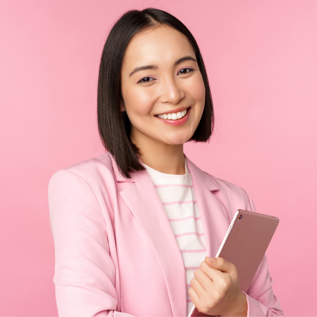 A virtual assistant woman in a pink jacket is holding a tablet and smiling.