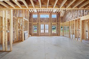 A house is being built with wooden beams and a lot of windows.