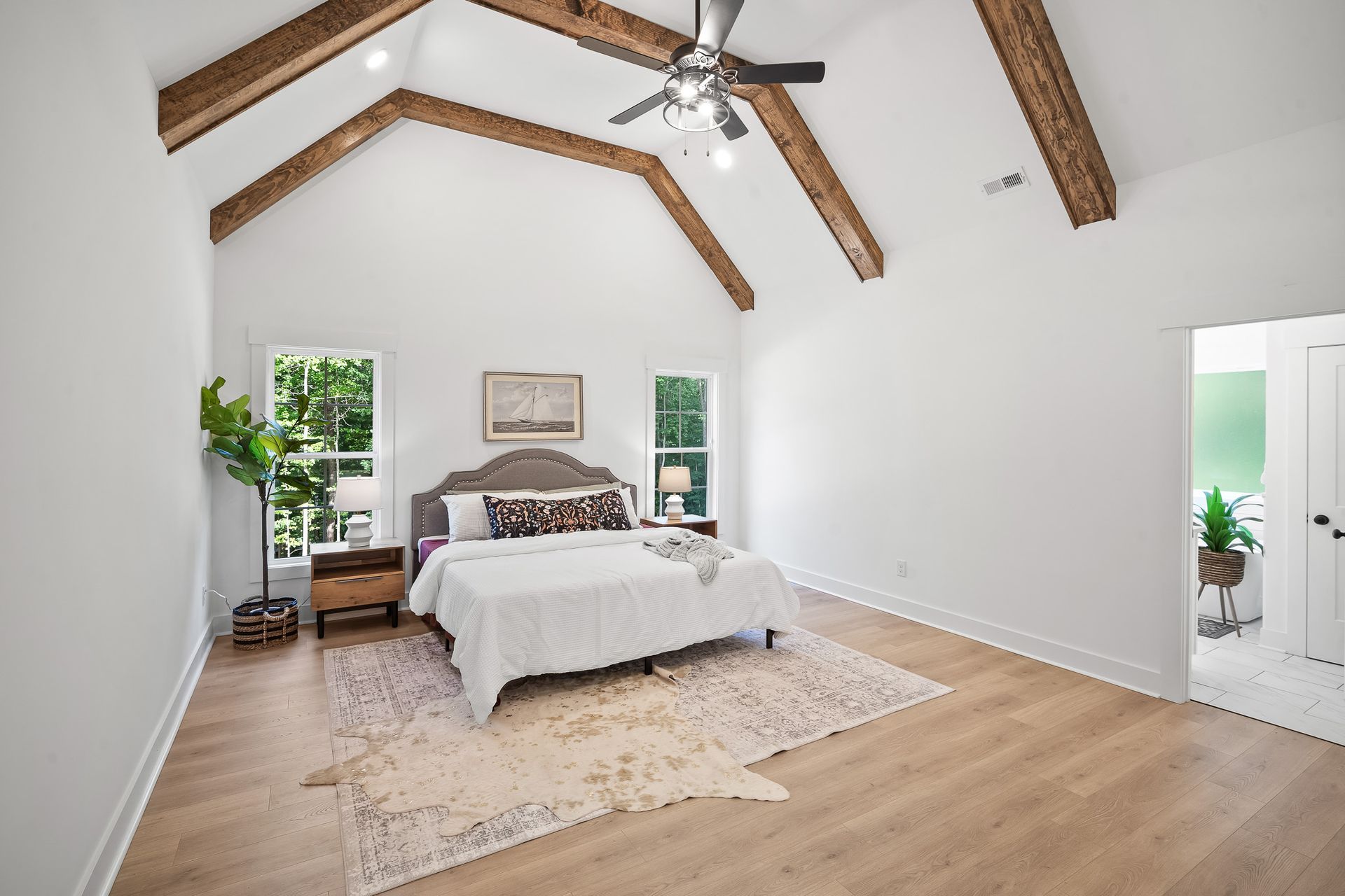 A bedroom with a ceiling fan and a bed.