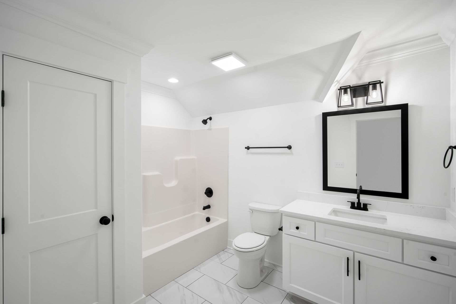 A bathroom with a toilet , sink , mirror and bathtub.