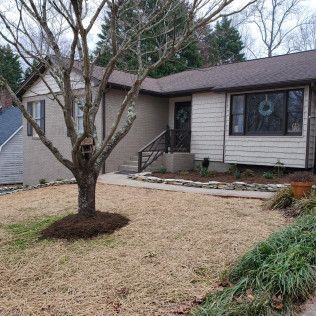Single-story house with beige siding, a front porch, and a leafless tree in the yard.