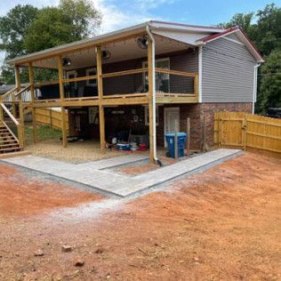 Two-story house with covered porch, stairs, and gravel yard area