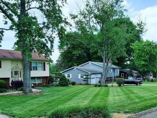A house with a lush green lawn in front of it.