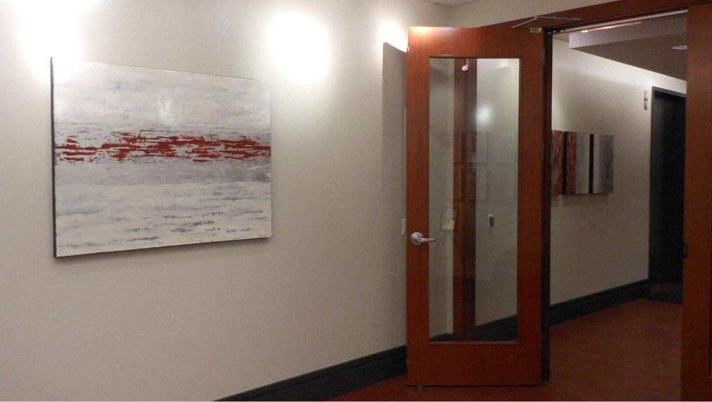 A hallway with a door and a painting on the wall