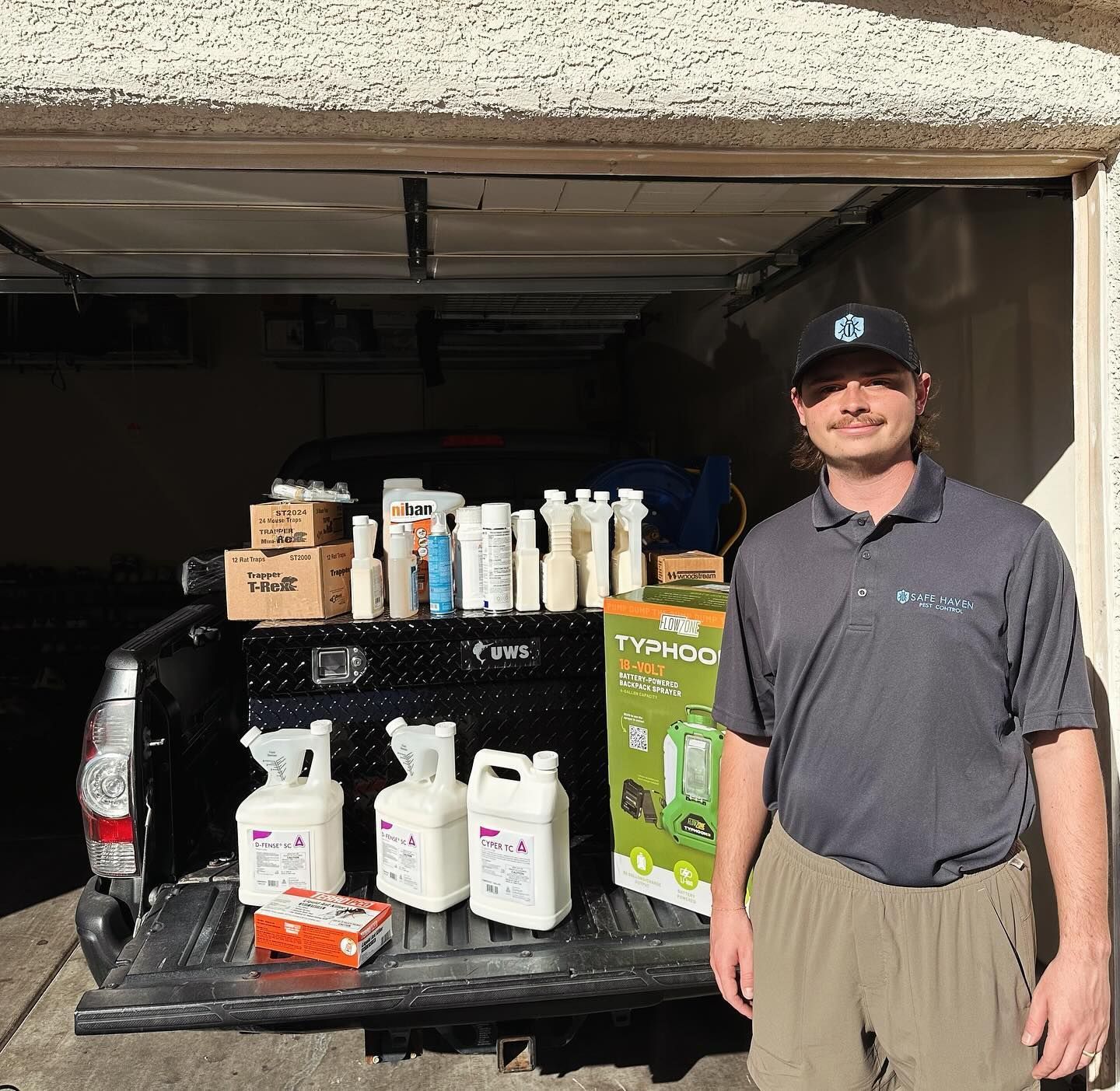 A man standing in front of a truck full of bottles and boxes