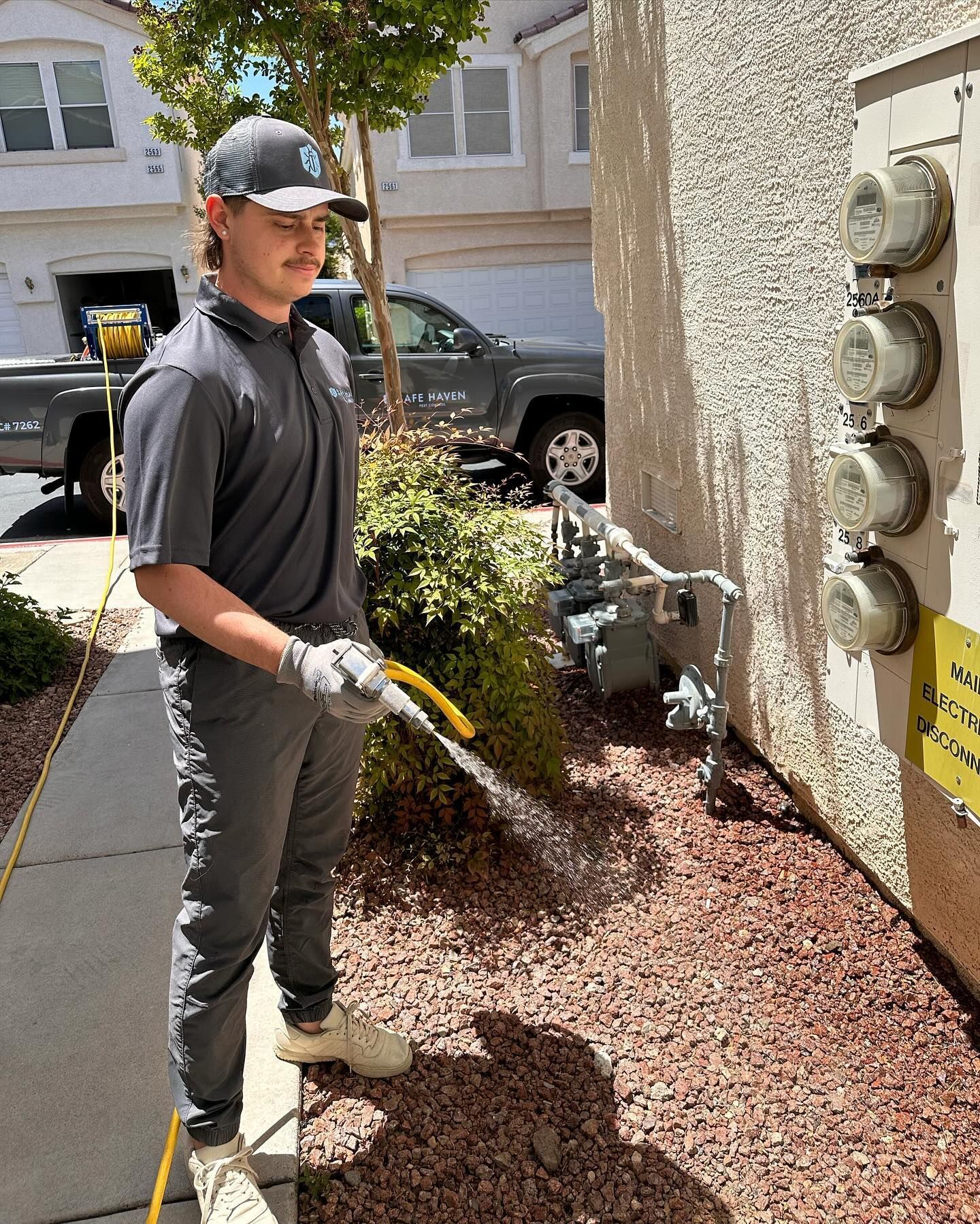 A man is spraying a house with a hose.