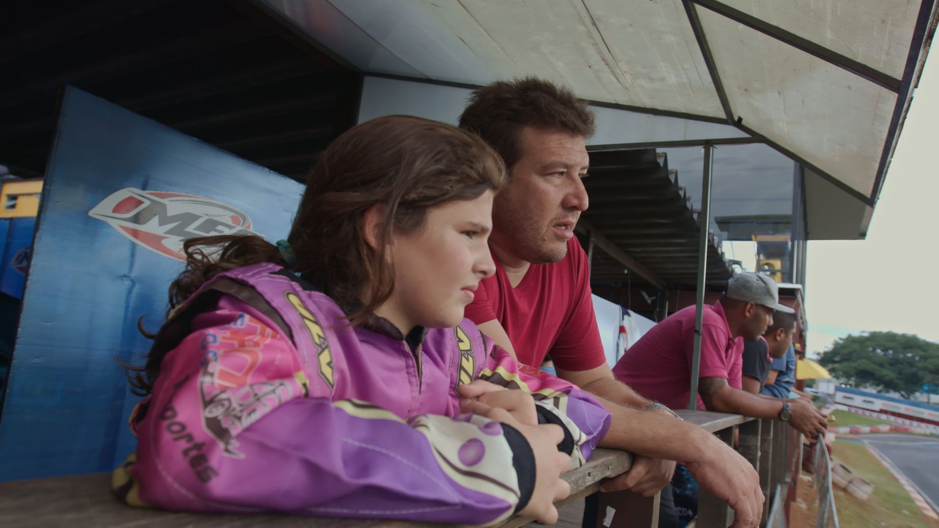 A man and a woman are sitting on a bench watching a race.