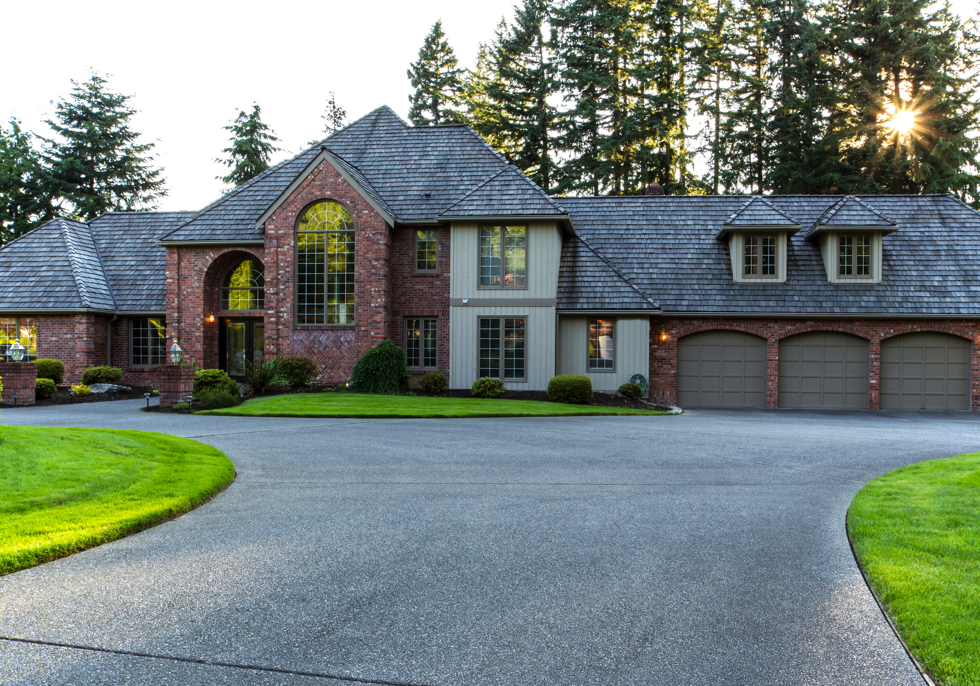 A large brick house with three garages and a driveway