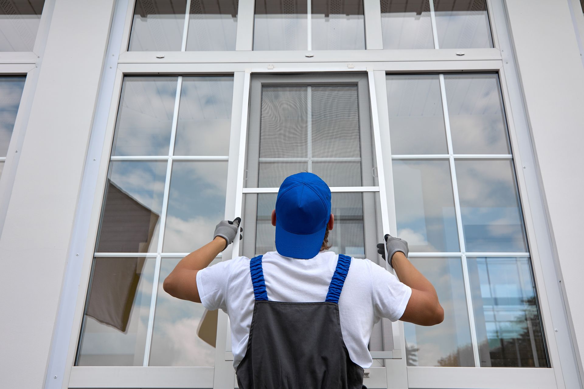 A man is installing a window in a house.