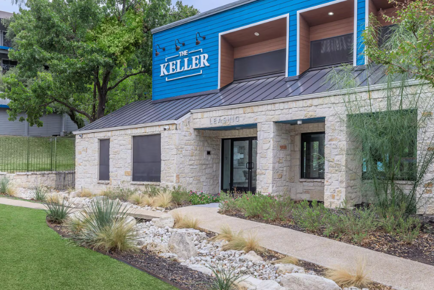 Keller office building with stone facade, blue upper level, and landscaped walkway