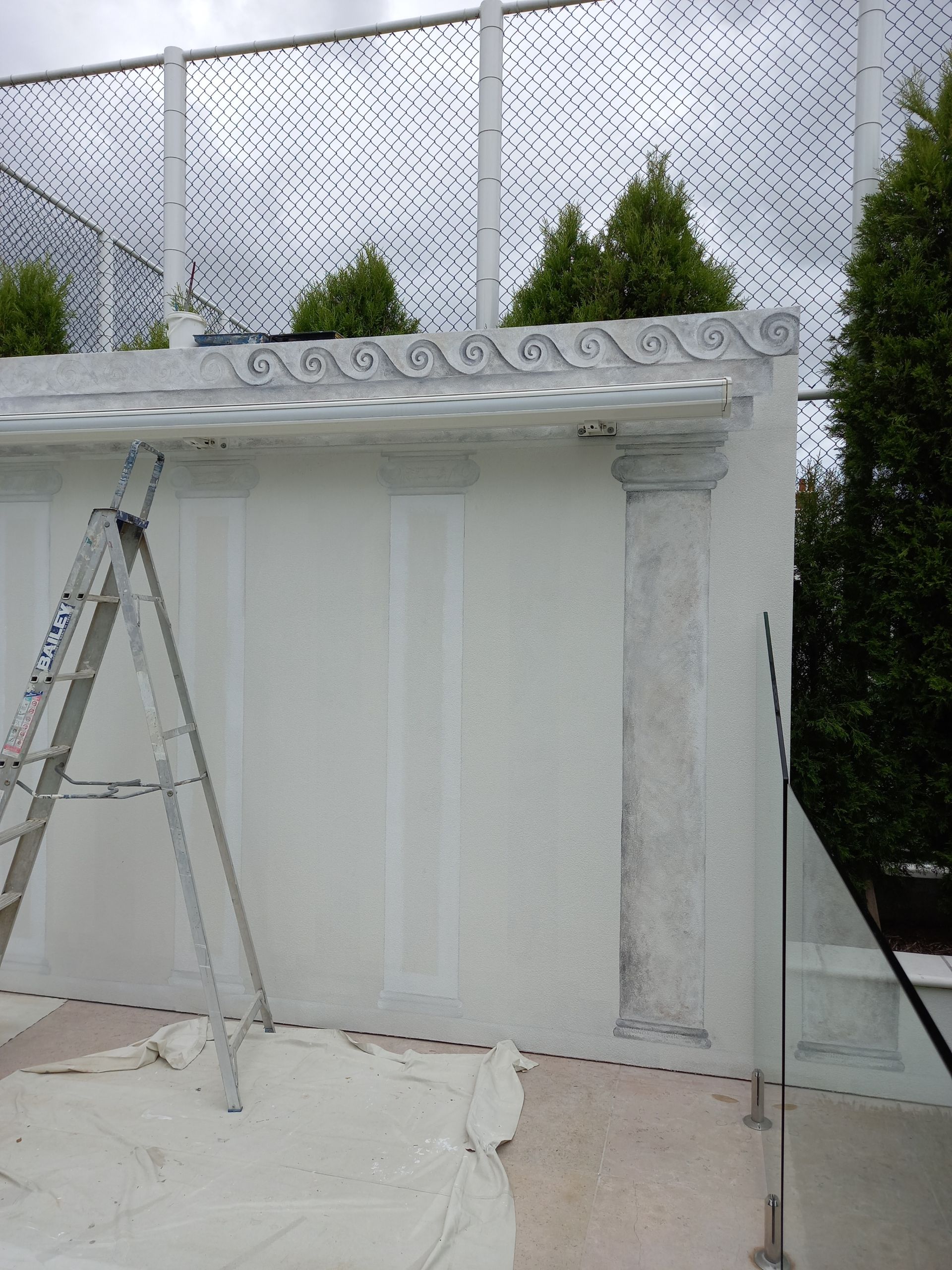 A ladder is sitting in front of a white wall.