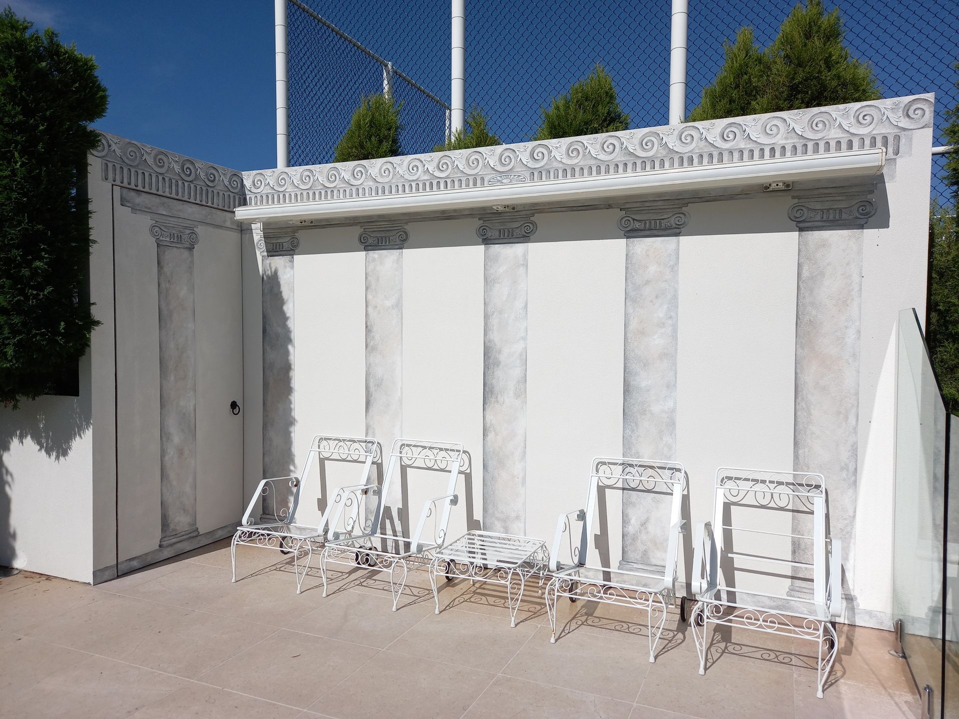A row of white chairs are sitting in front of a white wall.