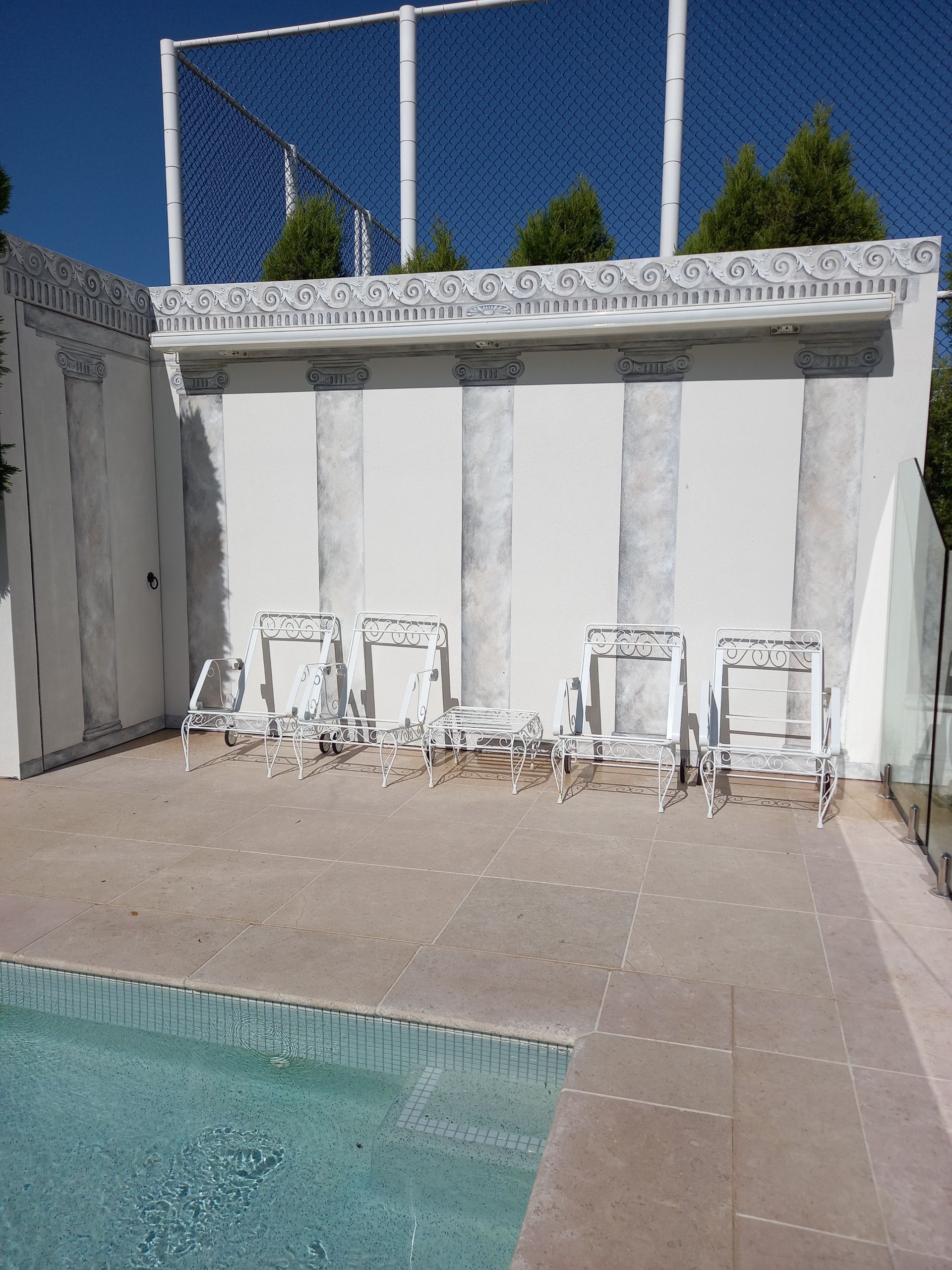 A row of chairs sitting next to a swimming pool