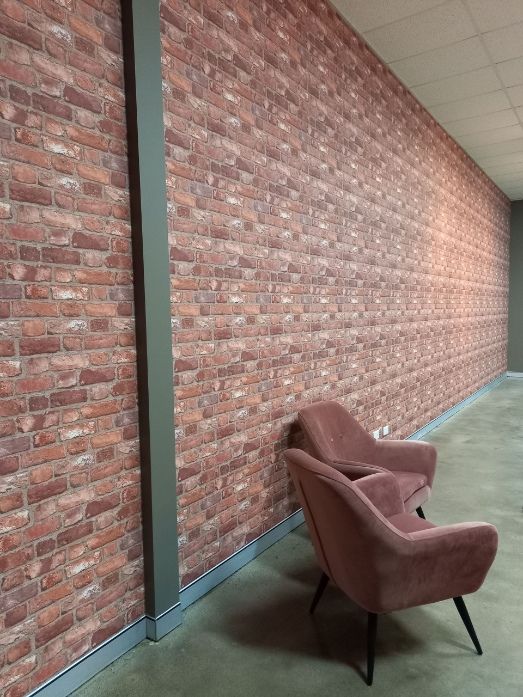 Two Chairs Are Sitting In Front Of A Brick Wall — Artizans International Specialised Paint Finishes in Robina, QLD