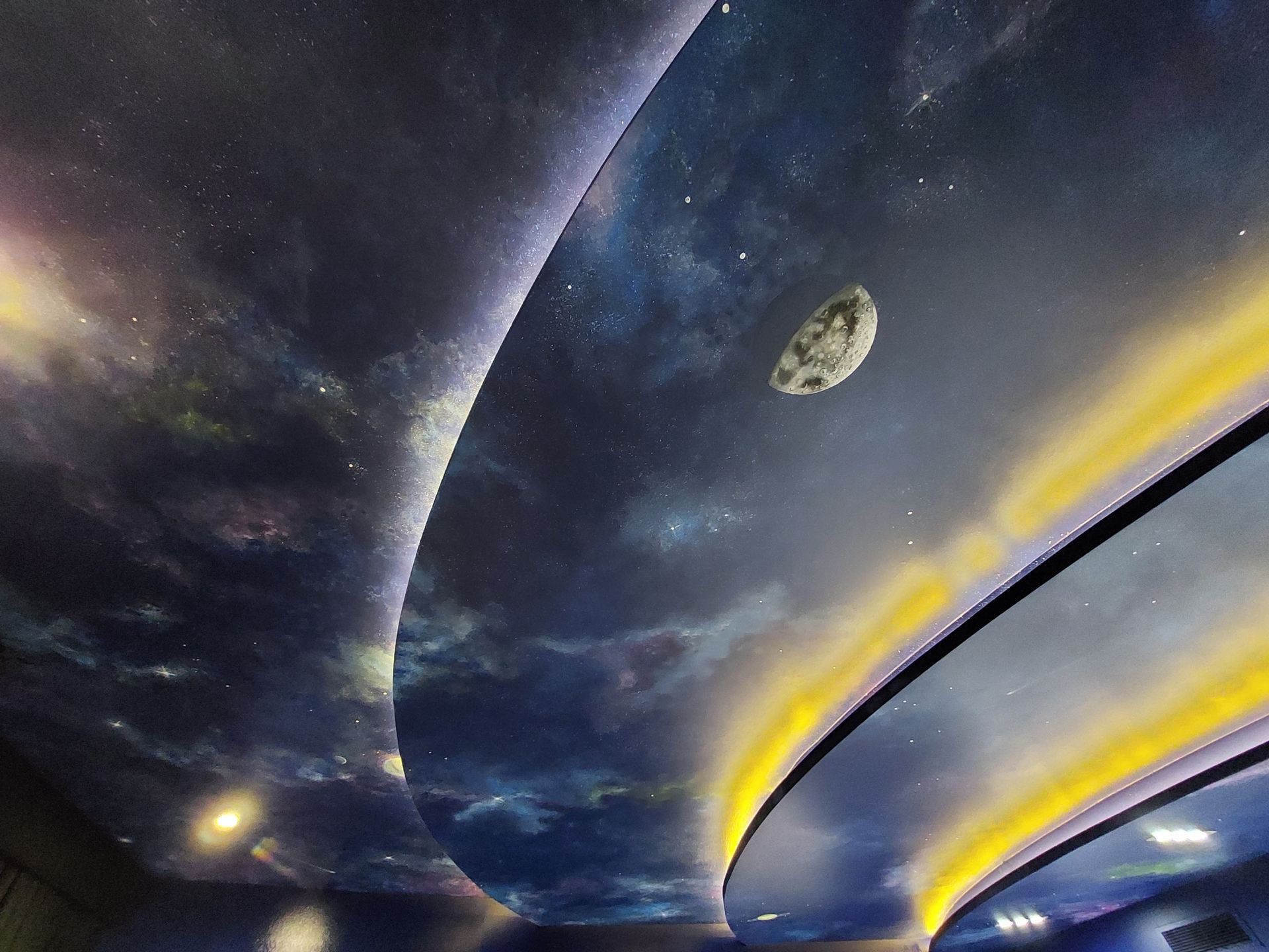 A ceiling with a picture of a planet and stars on it