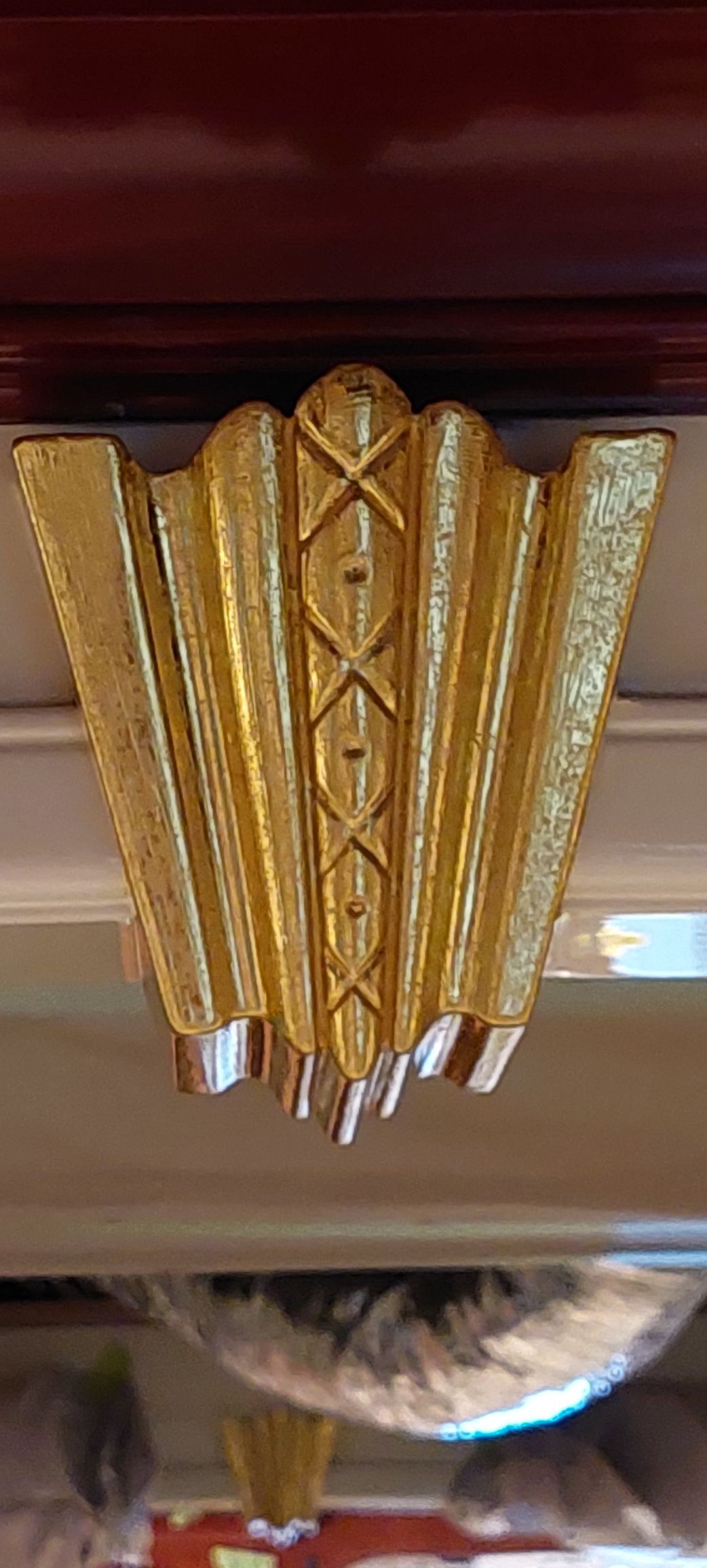 A gold fan is hanging from the ceiling of a room.