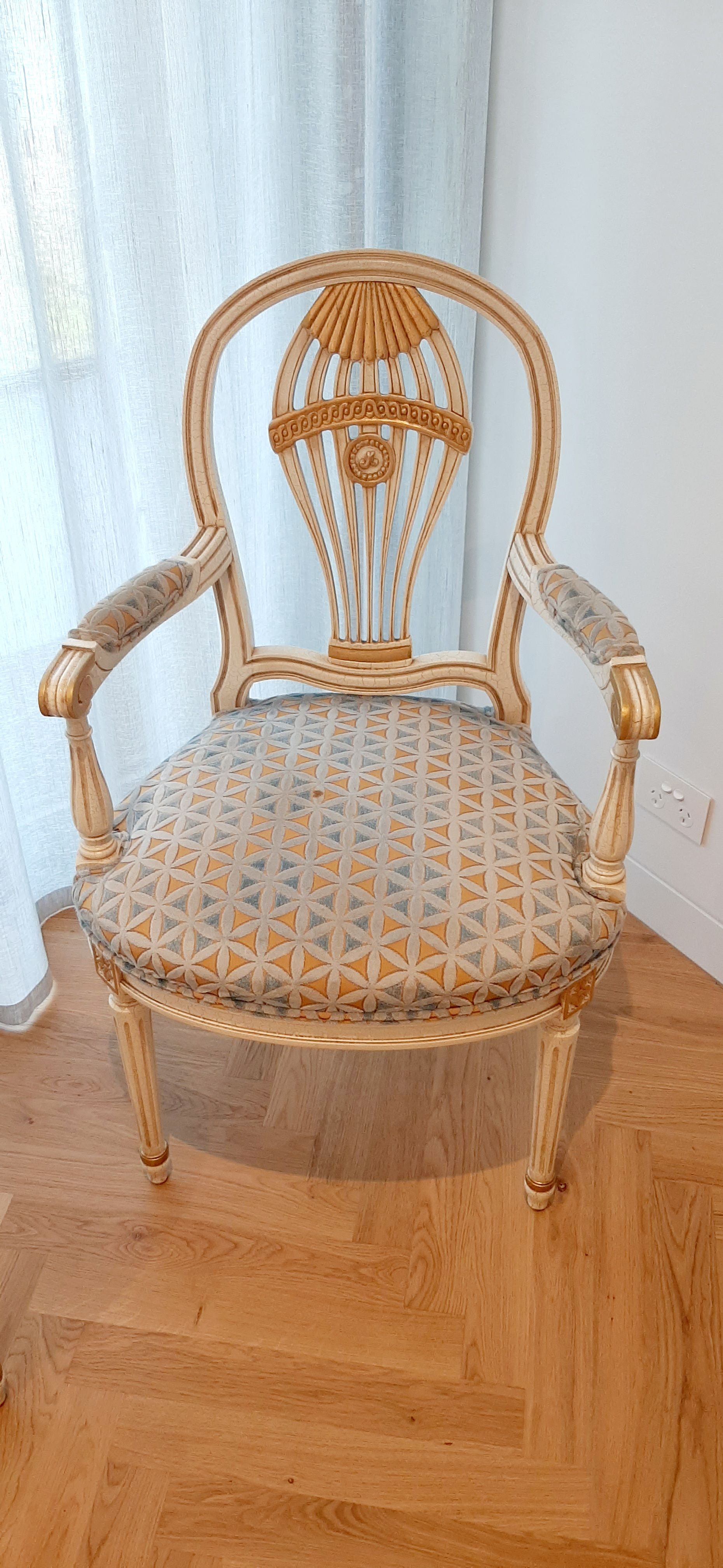 A chair is sitting on a wooden floor in a room next to a window.