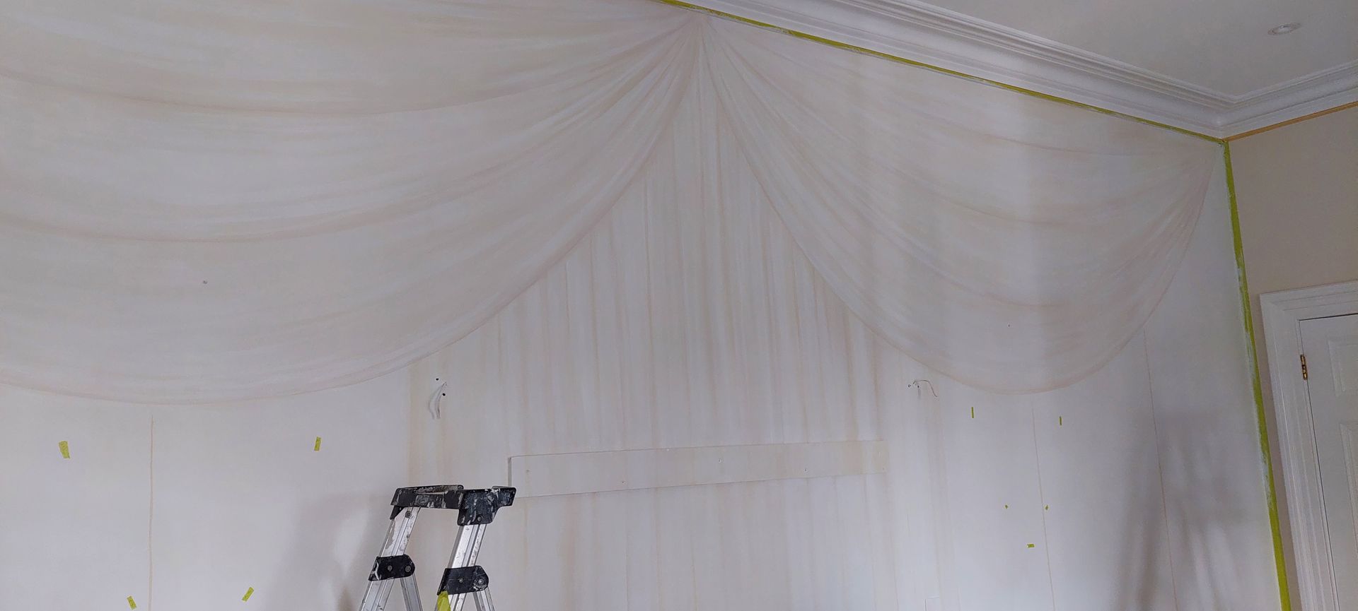 A ladder is sitting in a room next to a wall.