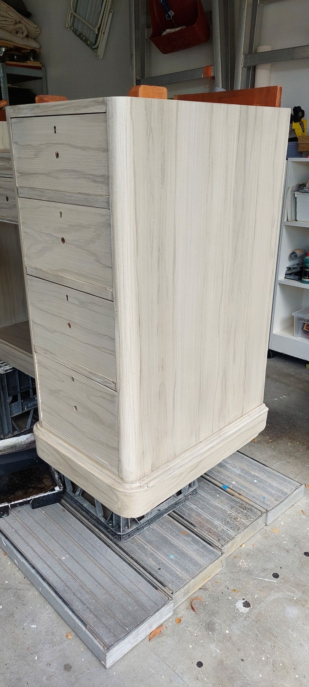 A wooden planter is sitting on top of a wooden table in a garage.