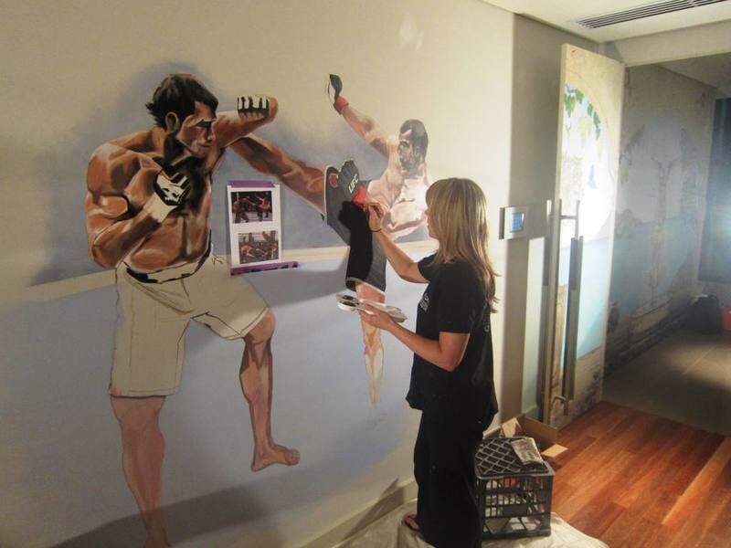 Woman Paints A Mural Art On The Wall — Artizans International Specialised Paint Finishes in Robina, QLD