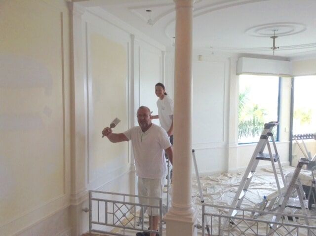Man And Woman Paints At The Palazzo Condo — Artizans International Specialised Paint Finishes in Robina, QLD