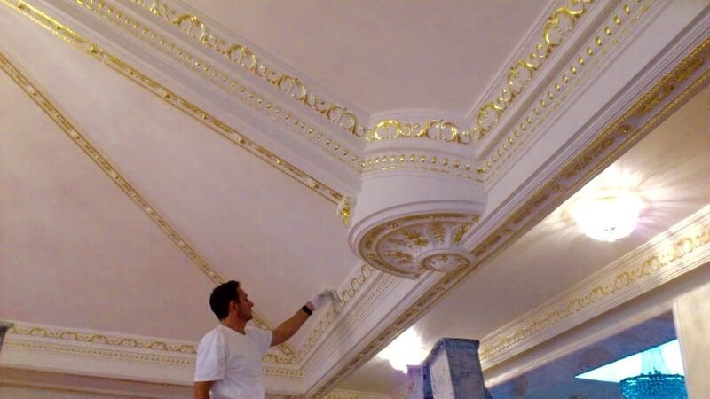 Man Paints A Gold On The Wall Ceiling — Artizans International Specialised Paint Finishes in Robina, QLD
