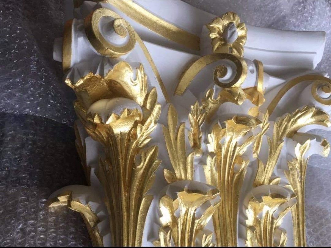 A white pillar with gold leaves and swirls