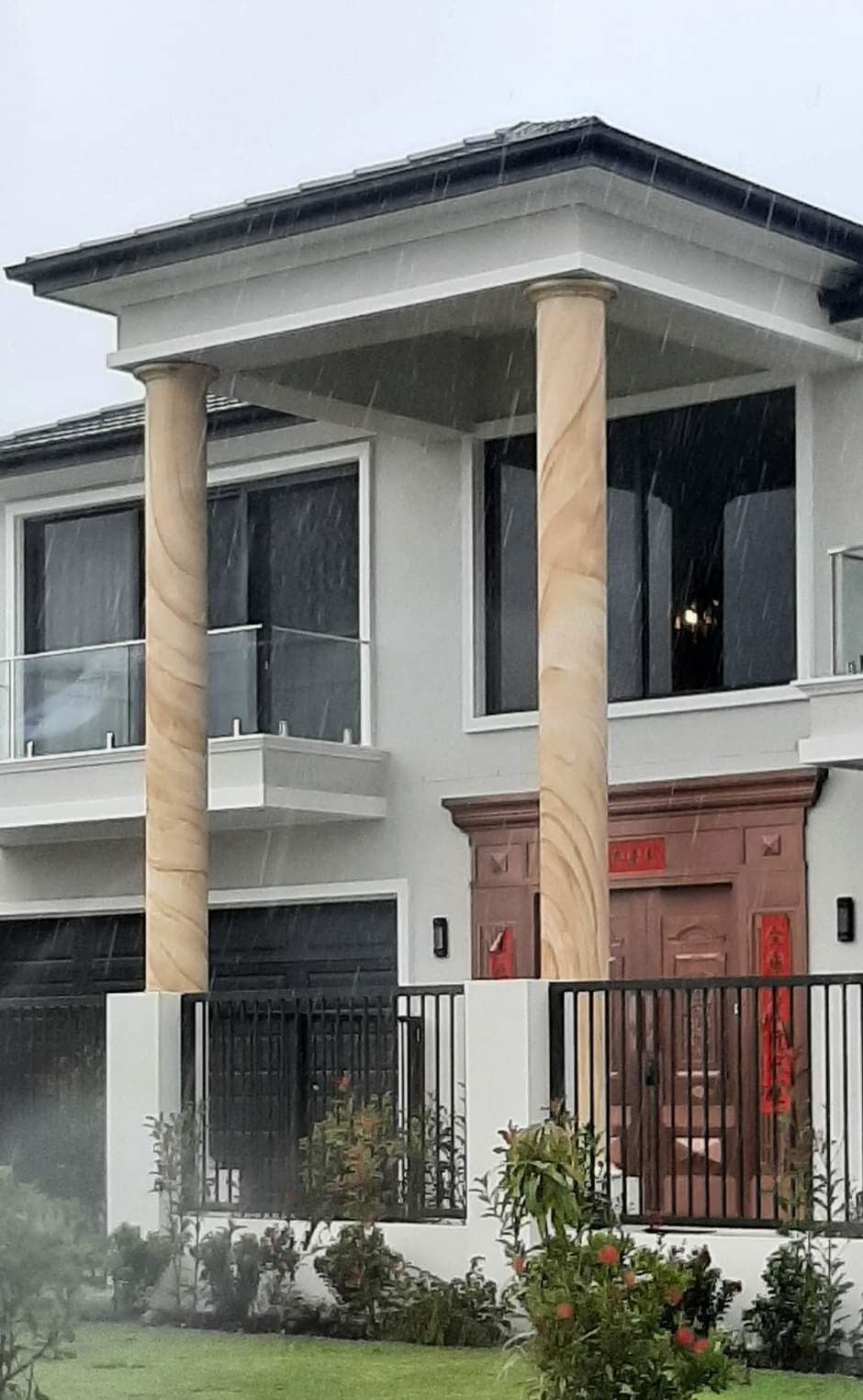 A large white house with columns and a fence in front of it.