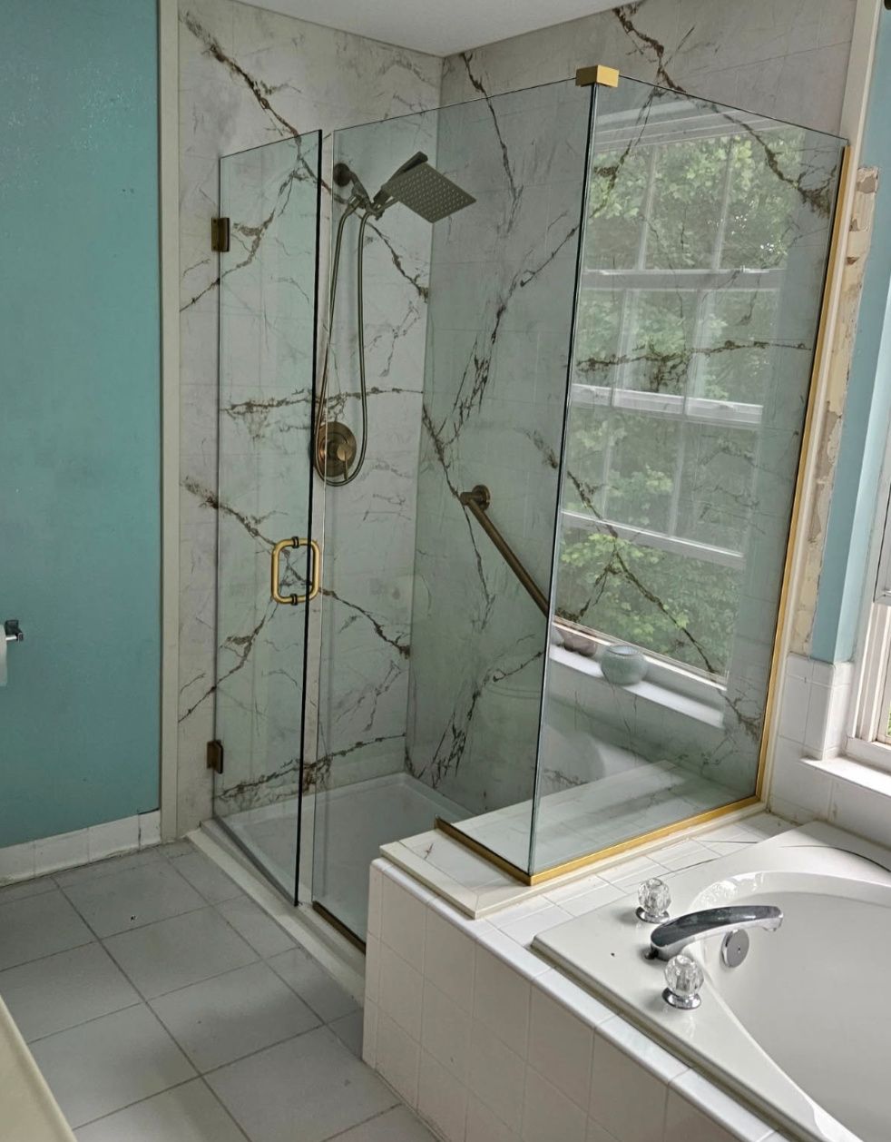 Frameless corner shower enclosure with brushed brass hardware installed in Baltimore, MD