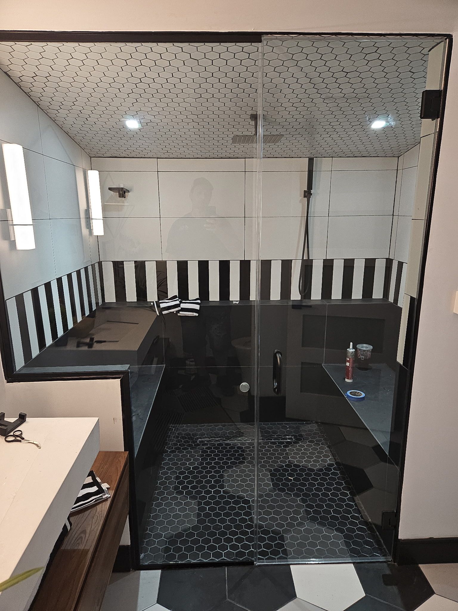 Floor-to-ceiling black-framed shower enclosure with hex tile in Baltimore, MD