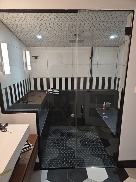 Floor-to-ceiling black-framed shower enclosure with clear glass and hex tile in Baltimore, MD