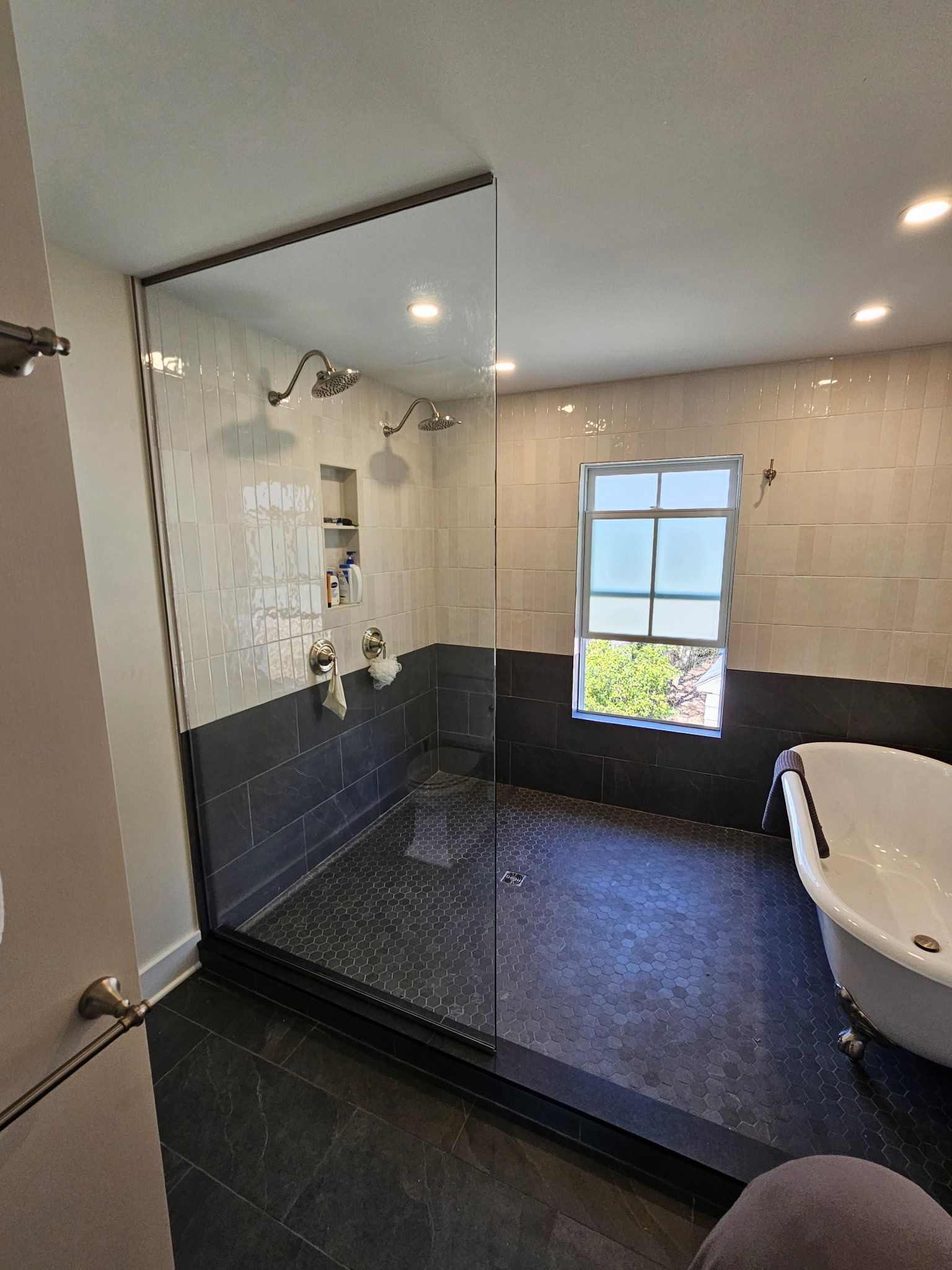 Frameless fixed-panel walk-in shower screen with dark tile in Baltimore, MD