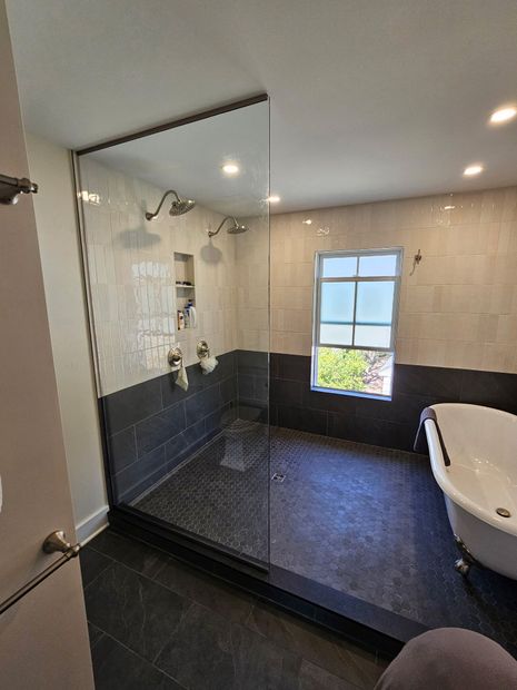 Frameless fixed-panel walk-in shower screen with clear glass and dark tile
