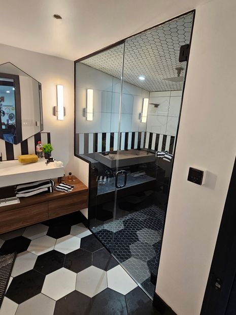 Frameless glass shower enclosure with black and white hex tile in Baltimore, MD