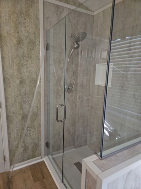 Frameless hinged corner shower enclosure with clear glass and brushed nickel hardware