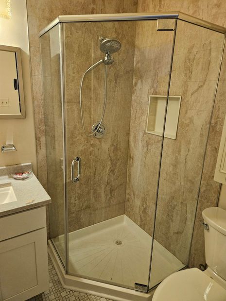 Frameless neo-angle shower enclosure with chrome hardware