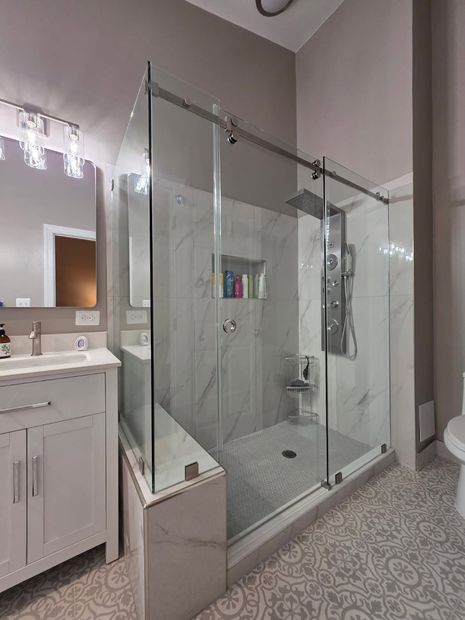 Frameless sliding shower door with fixed panel and chrome hardware