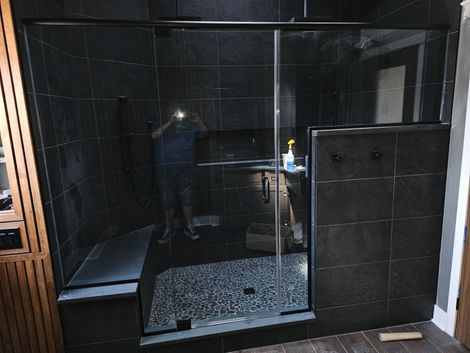 Large frameless shower enclosure with bench and matte black hardware