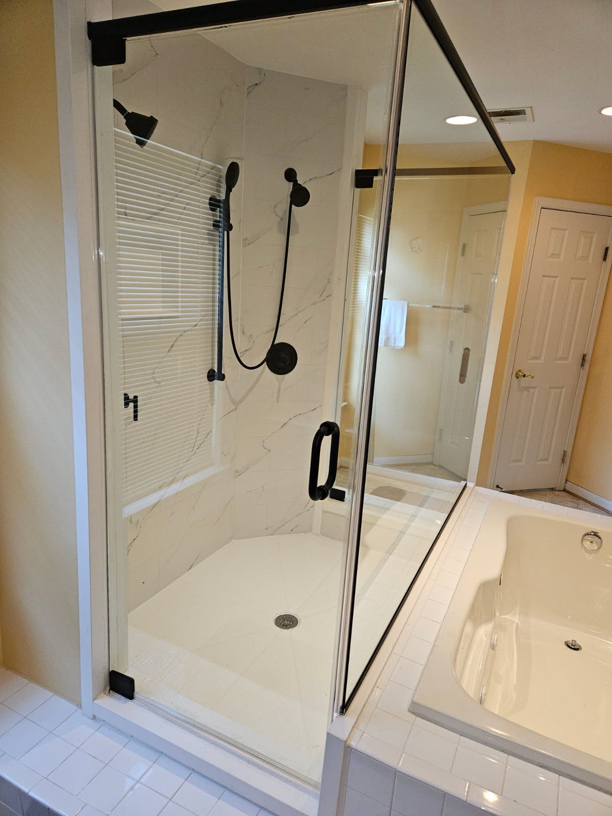 Matte black framed hinged shower door with return panel and D-pull handle in Baltimore, MD