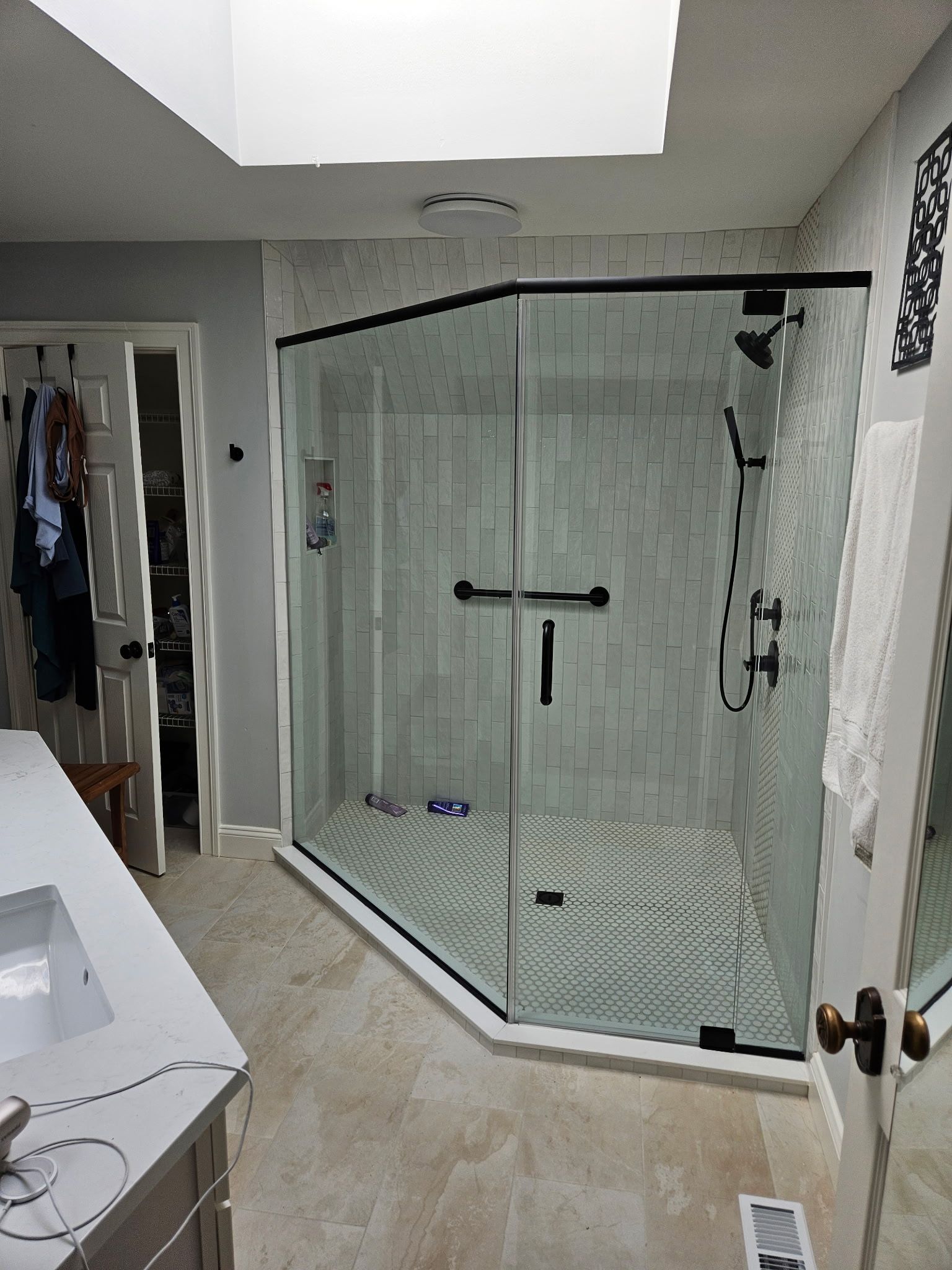 Matte black framed neo-angle shower enclosure under a skylight in Baltimore, MD