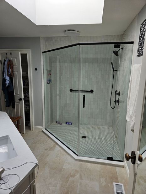 Matte black framed neo-angle shower enclosure under a skylight