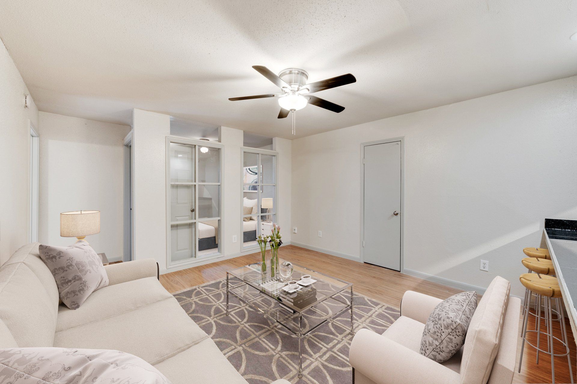 Modern living room at GIA Westchase with luxury flooring and ceiling fan, for Houston apartments.