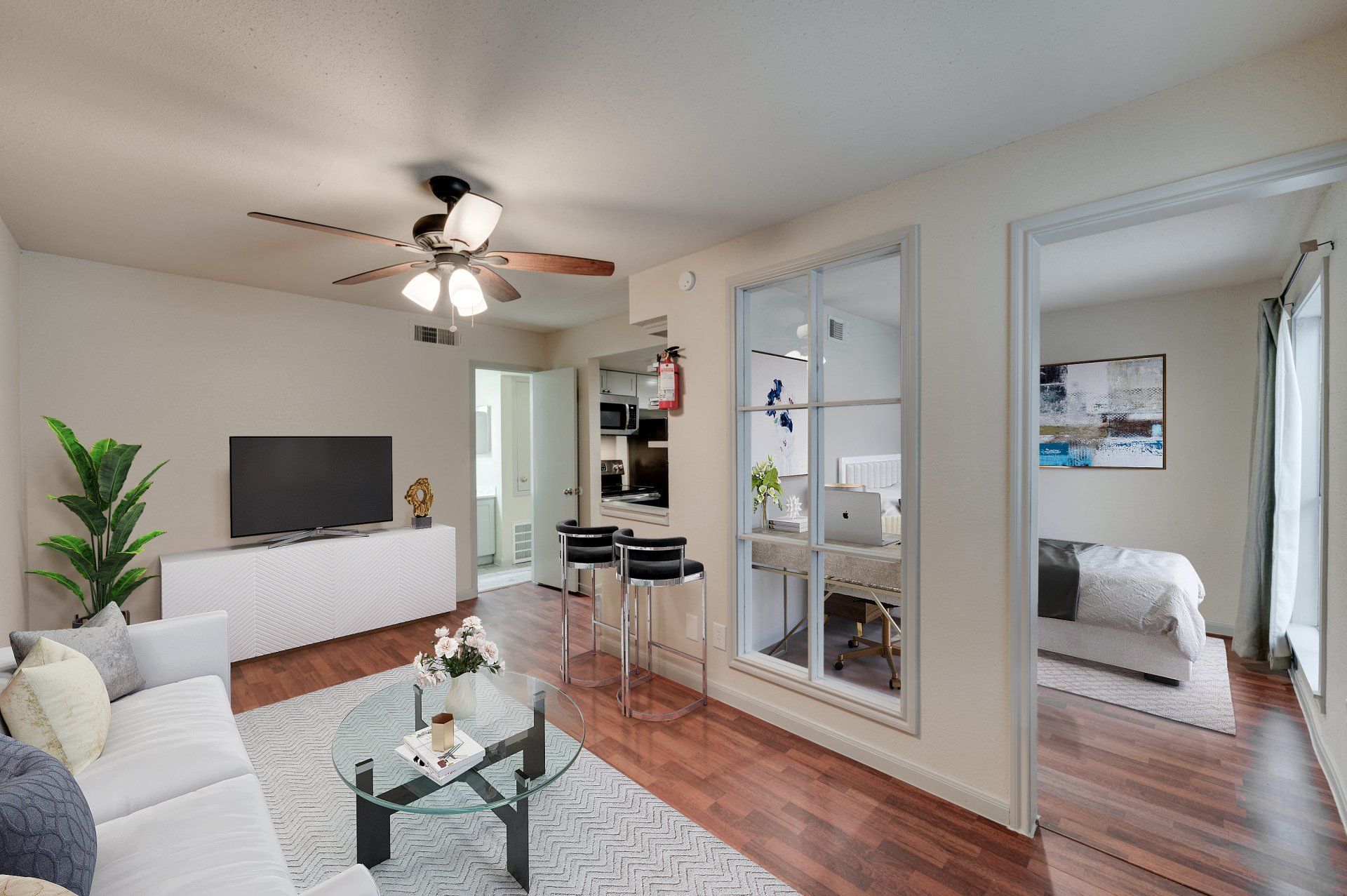 Modern living room at GIA Westchase with workspace and open kitchen, showcasing Westchase District Houston apartments.