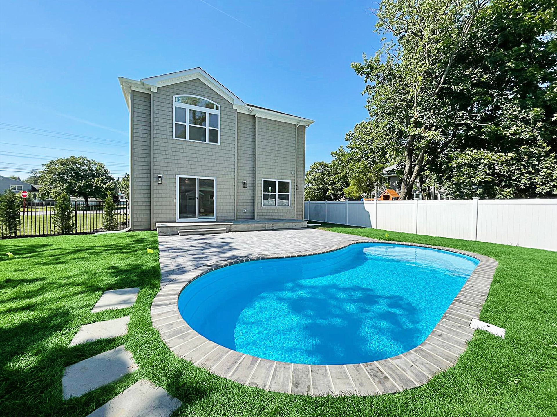 A large house with a large swimming pool in front of it.