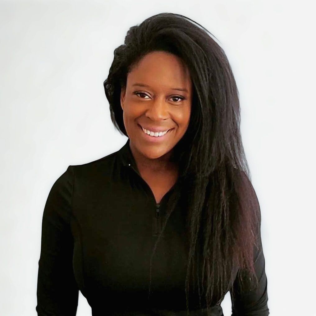 Woman with long dark hair smiles, wearing a black top against a white background.