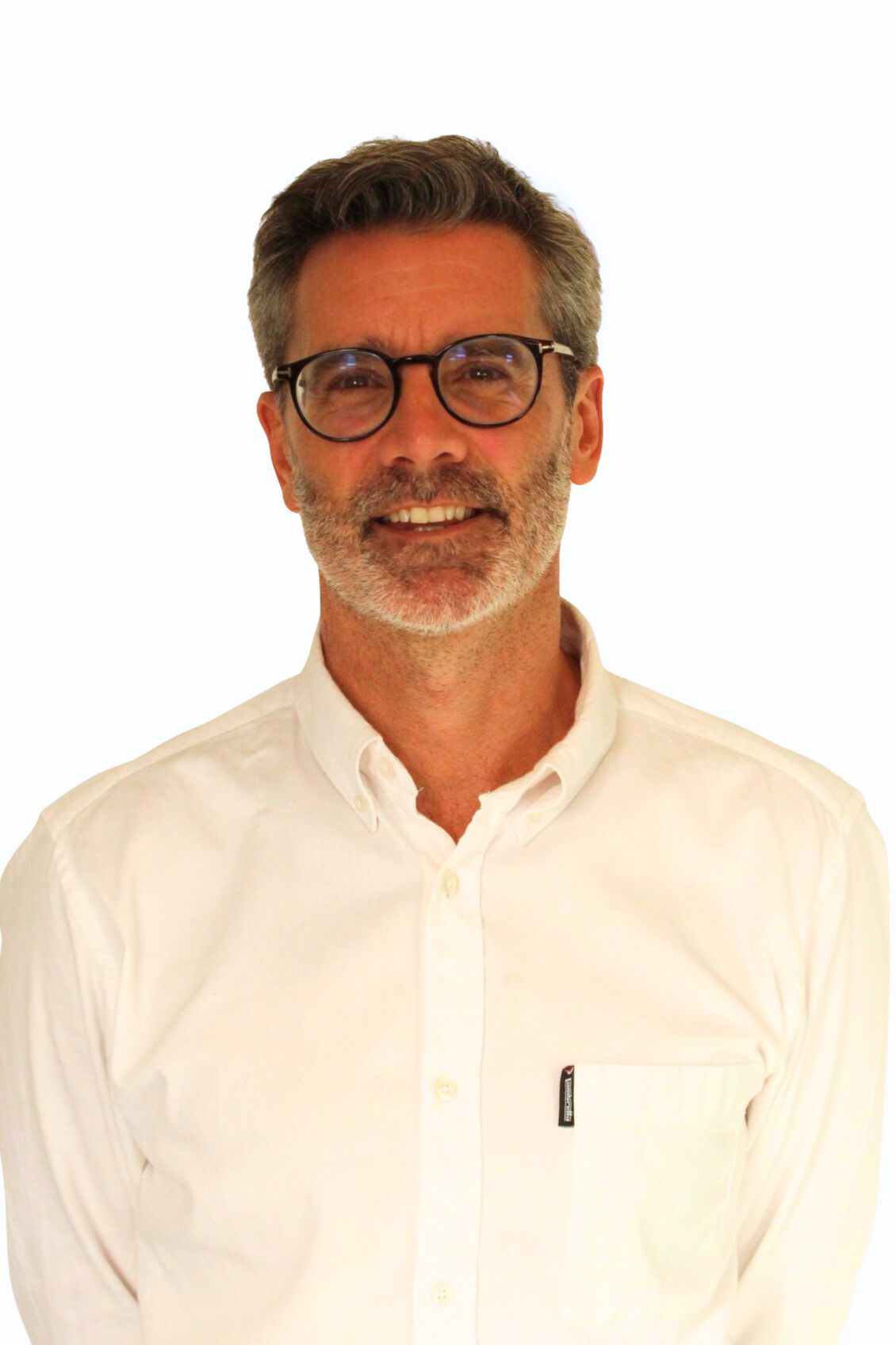 Man with glasses and a beard smiling, wearing a white button-down shirt.