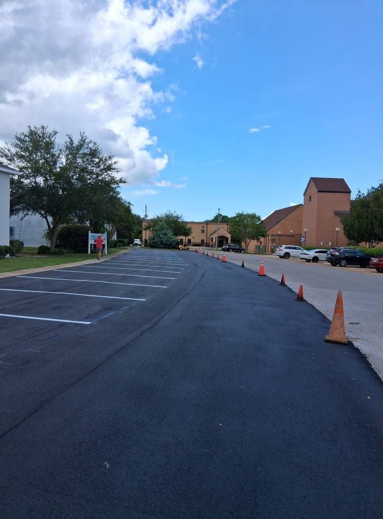 Newly paved parking lot with white parking lines.