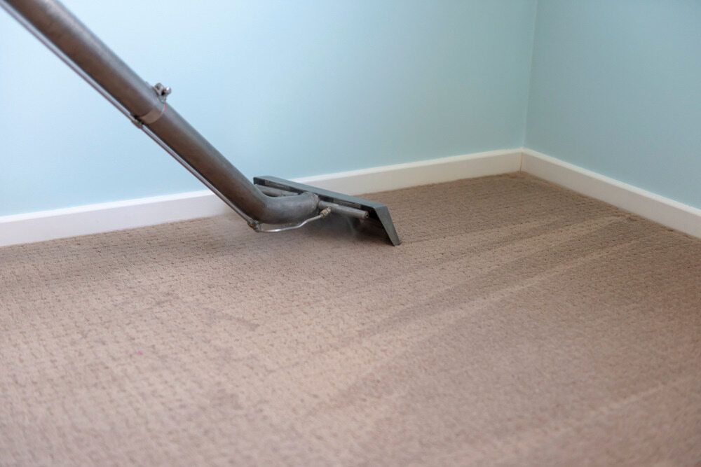 Vacuum Hose on Beige Carpet Near Wall Corner and Blue Wall — Broadbeach Carpet Cleaning In Surfers Paradise, QLD