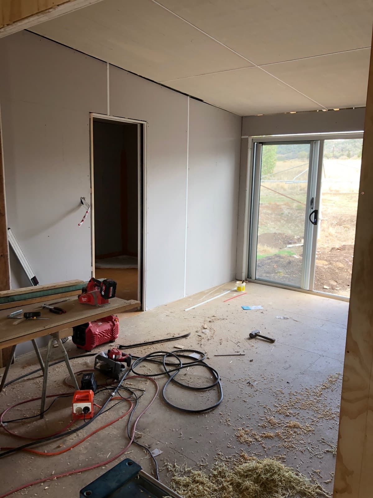 A Room with A Sliding Glass Door and A Table with Tools on It — Edwards & Froud Building Services Pty Ltd in Quirindi, NSW