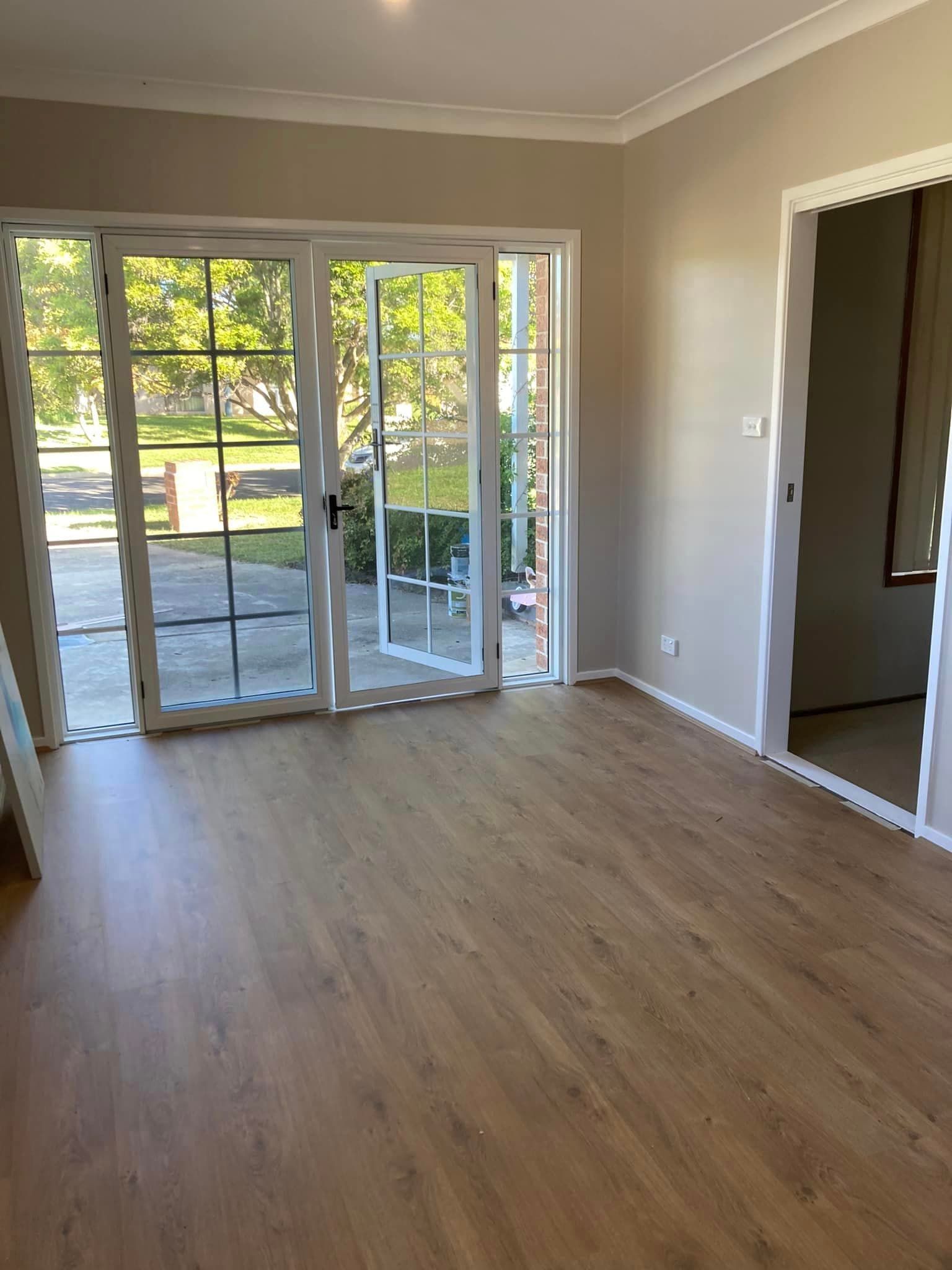 A Living Room with Hardwood Floors and Sliding Glass Doors — Edwards & Froud Building Services Pty Ltd in Narrabri, NSW
